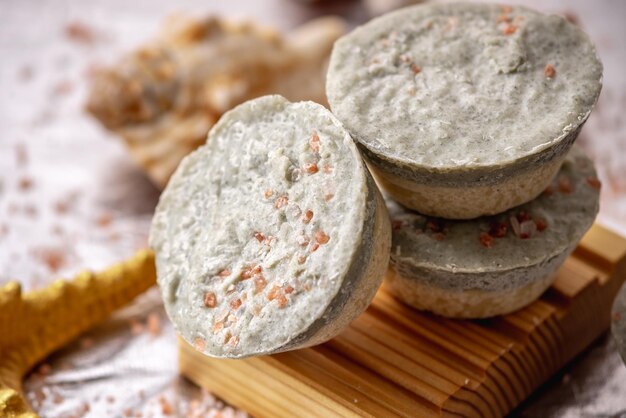 Sapone naturale con sale marino su un piatto di sapone di legno conchiglie e una stella di mare sapone estivo organico immerso nell'atmosfera marina