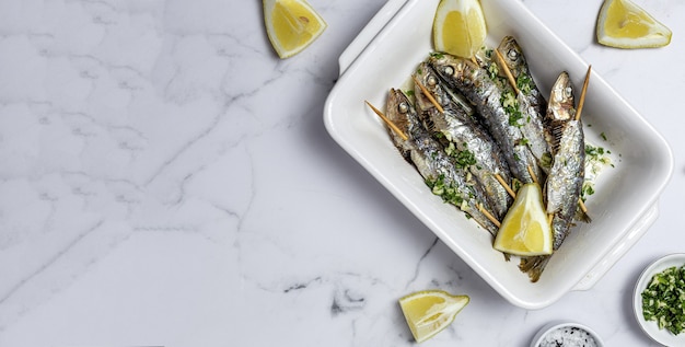 Sardine alla griglia fatte in casa con aglio, olio d'oliva, prezzemolo fresco e limone.concetto di cibo sano