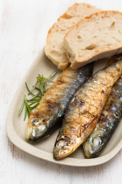 Sardine grigliate con pane sul piatto