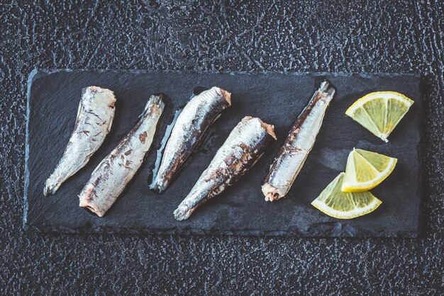 Sardine sul bordo di pietra nera