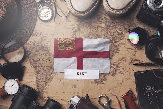 Sark Flag tra gli accessori del viaggiatore sulla vecchia mappa vintage. Colpo ambientale