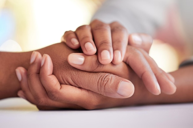 Sarò sempre qui per te Ritagliata di due persone irriconoscibili che si tengono per mano comodamente a un tavolo di casa