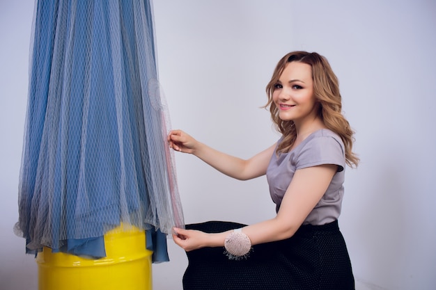 Sarta bella donna con i capelli lunghi e cliente. il sarto crea l'immagine per il cliente nell'officina di cucito. sarta misura ragazza con nastro di misurazione. Concept Fashion Design