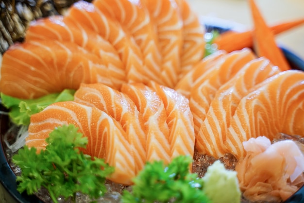 Sashimi di color salmone crudo della fetta del primo piano sul piatto