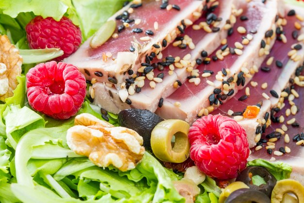 sashimi di tonno con insalata fresca, lamponi e noci