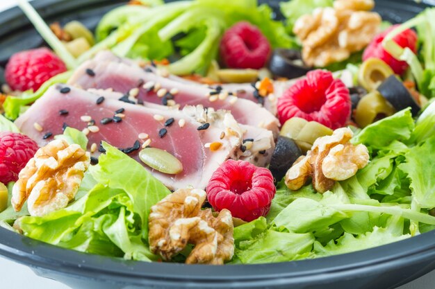 sashimi di tonno con insalata fresca, lamponi e noci