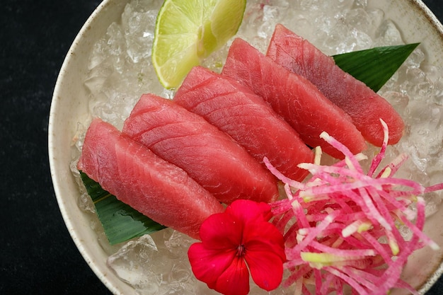 Sashimi di tonno con lime e ghiaccio su una foglia di bambù
