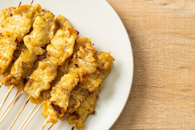 Satay di maiale con sottaceti di salsa di arachidi che sono fette di cetriolo e cipolle in aceto - Stile di cibo asiatico