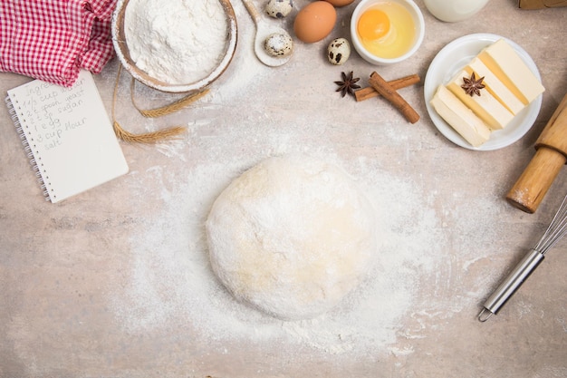 Sbattere la farina e gli utensili da cucina una teglia un mattarello con le uova sul tavolo Concetto di cottura al forno Chef che prepara pane e biscotti di pan di zenzero Il cuoco impasta e arrotola la pasta