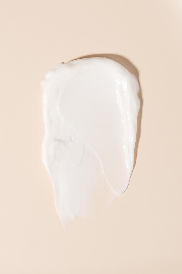 Sbavatura di consistenza cremosa del prodotto cosmetico su sfondo beige pastello