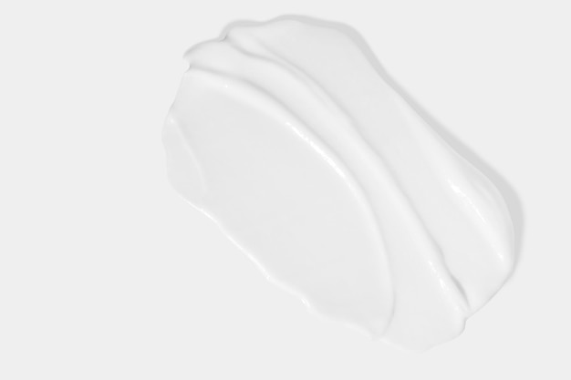 Sbavatura di sbavatura di crema di bellezza bianca su sfondo bianco Texture cosmetica del prodotto per la cura della pelle