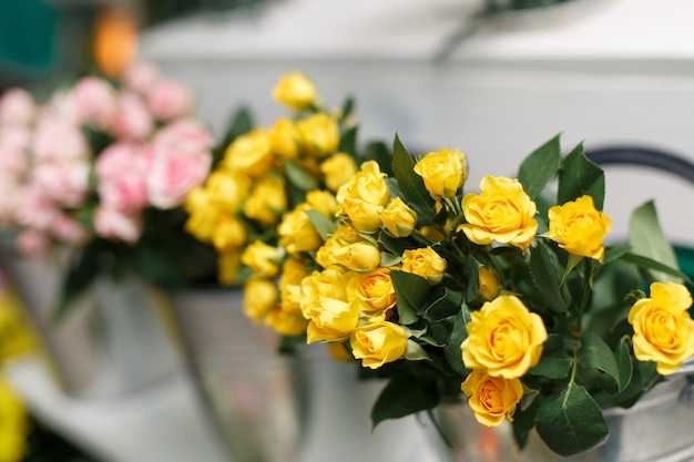 Scaffale con fiori gialli e rosa in negozio floreale