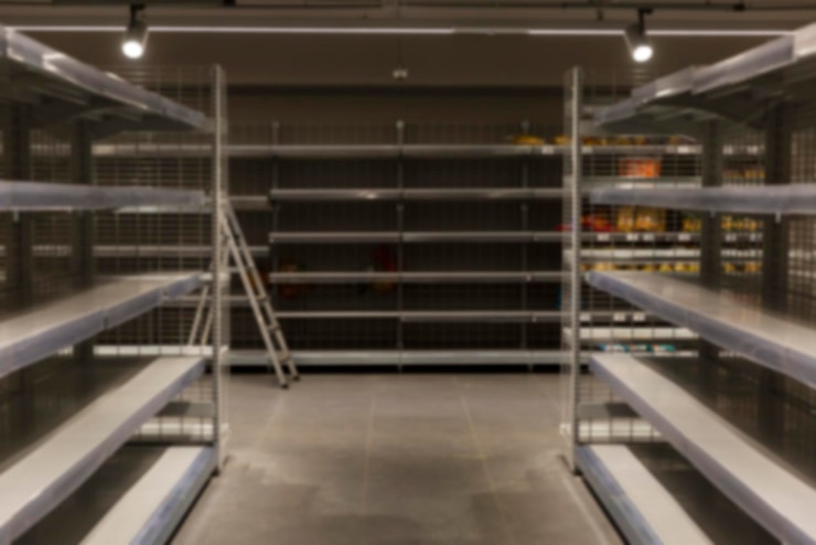 Scaffali vuoti in un supermercato. Fame e crisi alimentare. Sfocato.