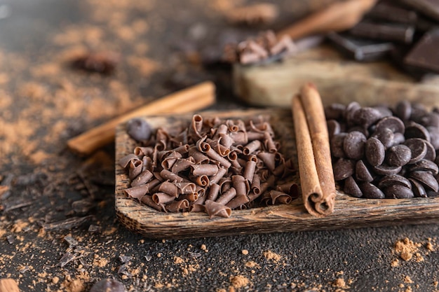 Scaglie e gocce di cioccolato con cacao in polvere e spezie Concetto di cibo dolce