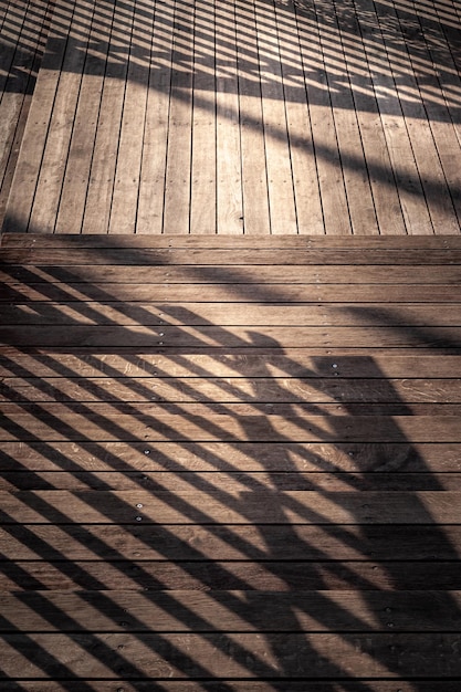 Scala con l'ombra della ringhiera Scala in primo piano con gradini in legno