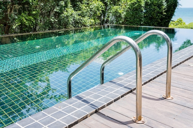 Scala delle barre di gru a benna nella piscina blu