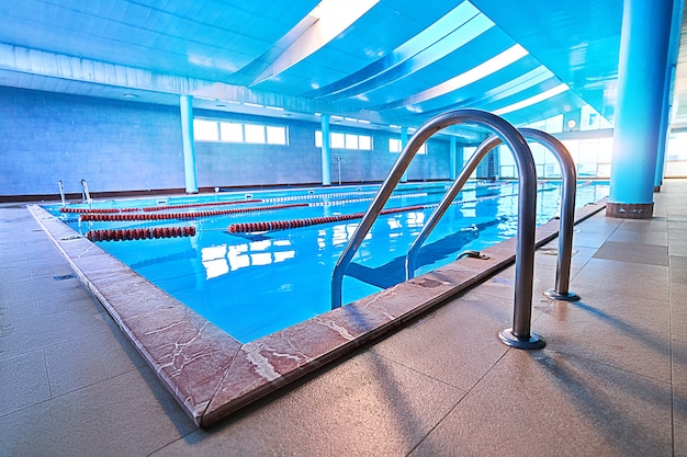 Scala dello stagno con le scale nello stagno vuoto per addestramento di nuoto di sport nel centro ricreativo