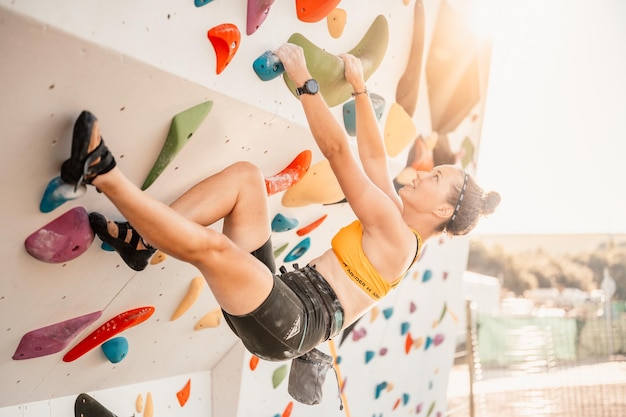 Scalatore che indossa l'attrezzatura da arrampicata Praticare l'arrampicata su una parete rocciosa all'aperto Xtreme concetto di sport e bouldering scalatore si arrampica su una parete rocciosa