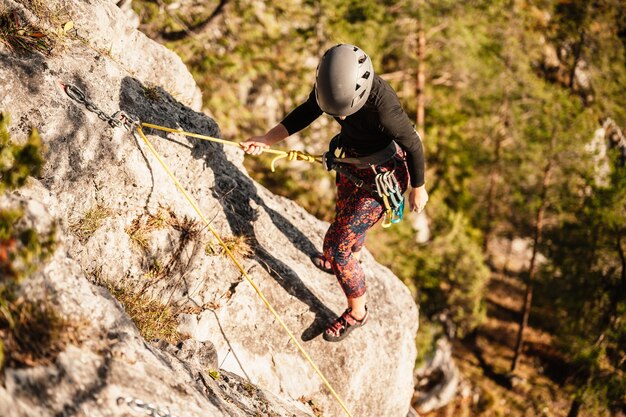 Scalatore che indossa l'attrezzatura da arrampicata Praticare l'arrampicata su una parete rocciosa Arrampicata sportiva e concetto di bouldering scalatore si arrampica su una parete rocciosa