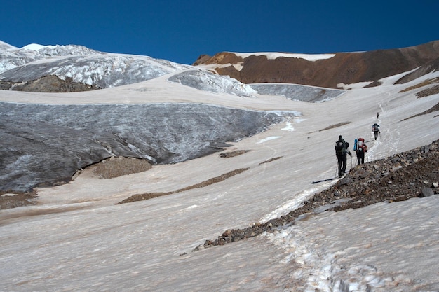 Scalatore che sale dal nevaio fino alla vetta alta