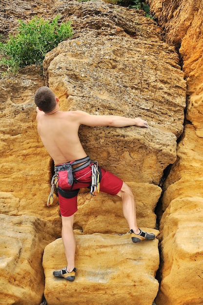 Scalatore che si arrampica su roccia