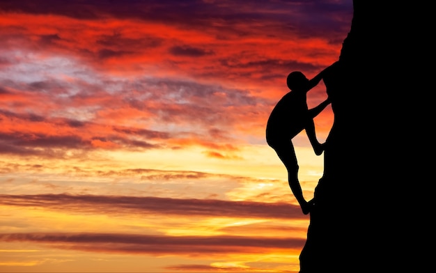 Scalatore di roccia a sfondo tramonto. Sport e vita attiva