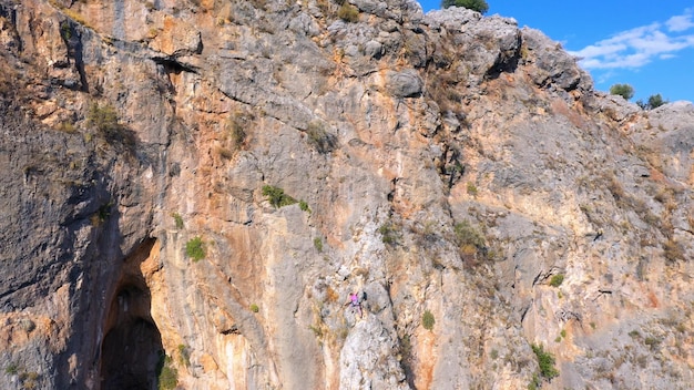 Scalatori di roccia che si arrampicano sulla vista aerea della scogliera dal concetto di avventura di alpinismo della gente del drone