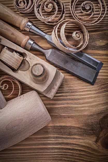 Scalpelli più solidi piano di rasatura trucioli arricciati maglio di legno su tavola di legno concetto di costruzione.