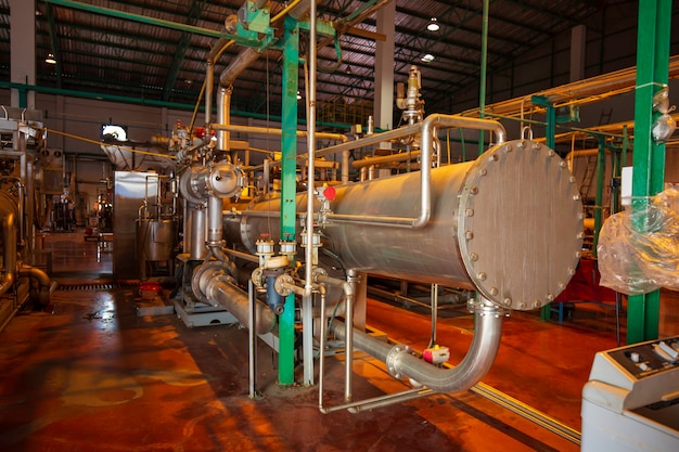 Scambiatore di calore all'isolamento nell'area di processo della conduttura che scorre prodotto chimico inossidabile lucido in fabbrica.