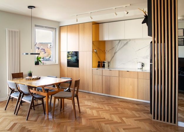 scandi open space interno di cucina e sala da pranzo con tavolo familiare e accessori da cucina