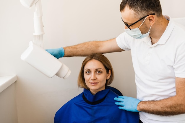 Scansione a raggi x dei denti per rilevare il mal di denti e trattare le radici Il dentista esegue la scansione dei denti a raggi x per la donna in odontoiatria