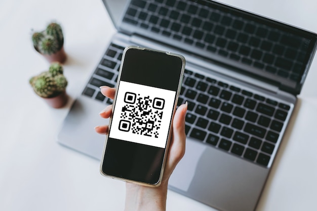 scansione del codice qr pagamento e concetto di tecnologia senza contanti la mano femminile utilizza un telefono cellulare