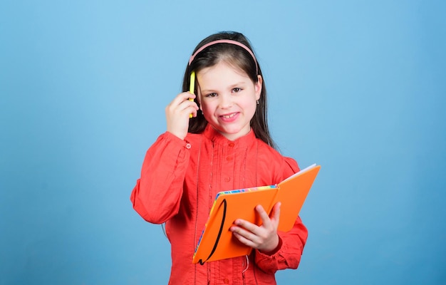 Scarabocchi sul margine di un libro Adorabile scolara che legge e scrive sul quaderno Bambina carina con libro di attività Bambino piccolo con libro di lavoro