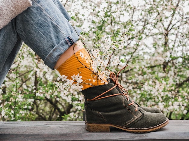 Scarpe alla moda e calzini luminosi sullo sfondo di un albero in fiore. Avvicinamento. Stile maschile e femminile. Bellezza, concetto di eleganza