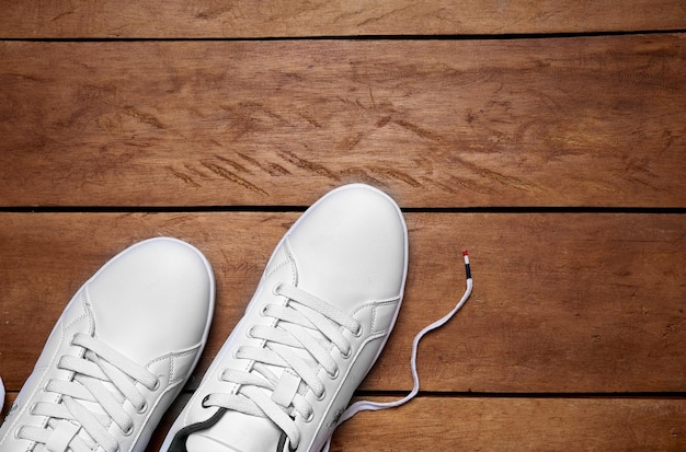 scarpe bianche sullo sfondo di legno. idea di viaggio e vestiti comodi. calzature in pelle