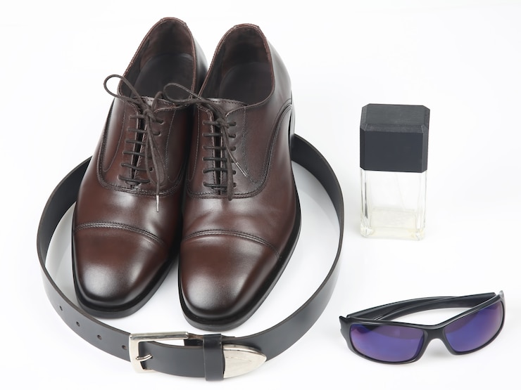 Foto scarpe, cintura e occhiali da uomo classici su sfondo bianco