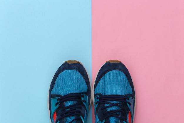 Scarpe da corsa (sneaker) su sfondo rosa pastello blu. Stile di vita sano, allenamento fitness. Vista dall'alto