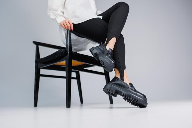 Scarpe da donna Primo piano di gambe femminili in leggings neri e mocassini in pelle nera Nuova collezione primavera-estate di scarpe da donna in pelle