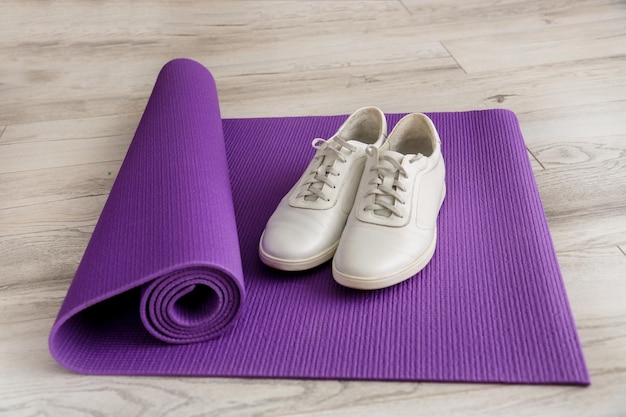 Scarpe da ginnastica bianche su un tappetino ginnastico viola per l'allenamento sportivo