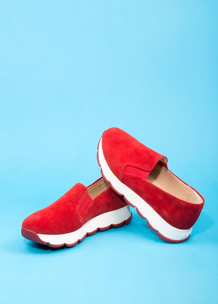 Scarpe da ginnastica da donna rosse su sfondo blu