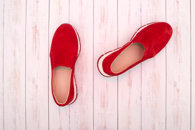 Scarpe da ginnastica da donna rosse su una superficie di legno