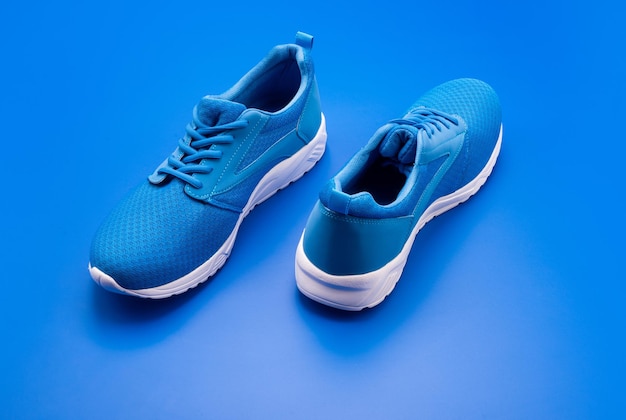 Scarpe da ginnastica sportive blu su sfondo blu negozio di scarpe concetto di shopping calzature per l'allenamento calzature atletiche per la corsa paio di comode scarpe sportive