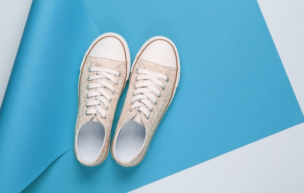 Scarpe da ginnastica su sfondo di carta avvolta. Tendenza colore, moda minimalista still life. Vista dall'alto