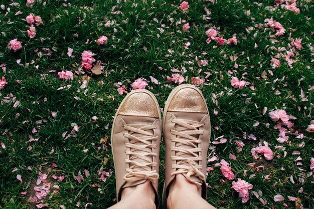 Scarpe da ginnastica sullo sfondo di erba e fiori caduti