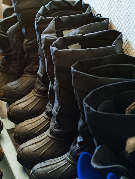 Scarpe da lavoro calde Gli stivali industriali invernali dei lavoratori stanno in fila nell'essiccatoio Sullo sfondo