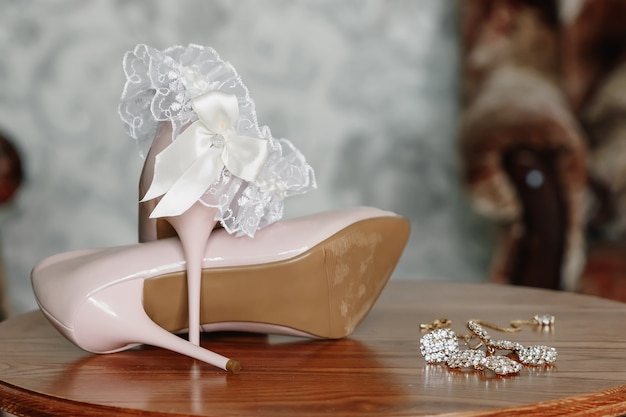 Scarpe da sposa biege sul tallone su un tappeto.