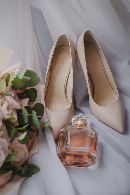 Scarpe da sposa con bouquet da sposa e profumo sul velo. Concetto di matrimonio