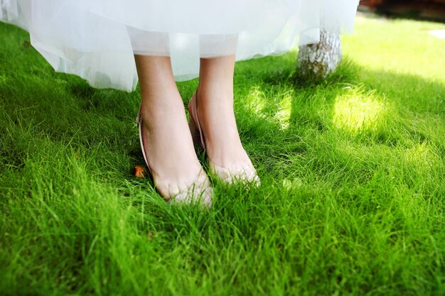 Scarpe da sposa della sposa sull'erba verde