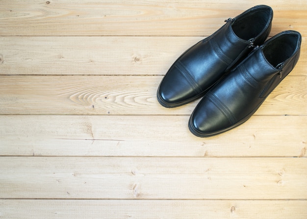 Scarpe da uomo nere di pelle su un pavimento di legno.