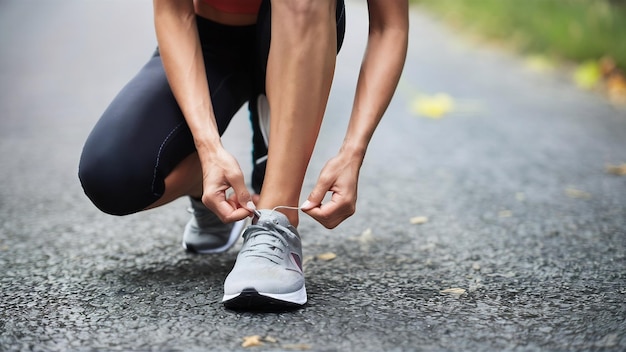 Scarpe da vicino corridore femminile che si lega le scarpe per un esercizio di jogging